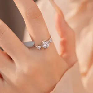 Detailopname van een sprankelende ruitvormige zirkonia ring gedragen aan een vinger.