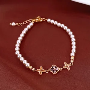 Bracelet perles zircon style français avec breloques fleurs dorées sur fond rouge