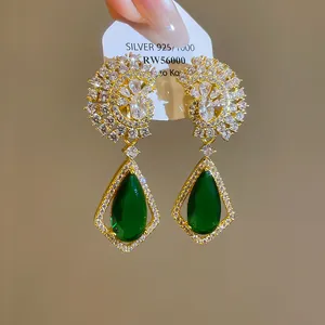 Dettaglio degli orecchini pendenti a goccia in zircone verde smeraldo stile vintage