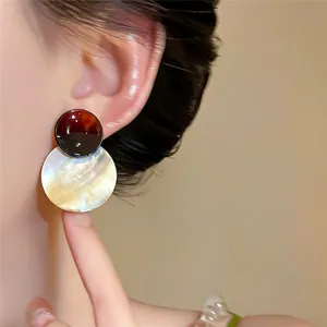 Detailansicht eleganter runder Muschelohrhänger mit einem Retro-Schildpatt-Stecker