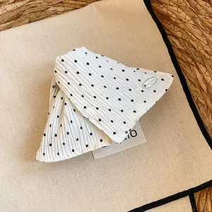 Detail van een elegante haarclip van witte en zwarte stof met stippen