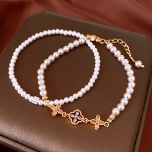 Detail view of an elegant pearl bracelet with zircon flower charms on jewelry box