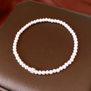Detailed view of an elegant French-style pearl bracelet with a sparkling zircon flower bead.
