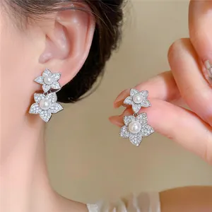 Exquisite silberne Blumenohrringe mit Zirkonia-Pavé und Perlen, am Model getragen
