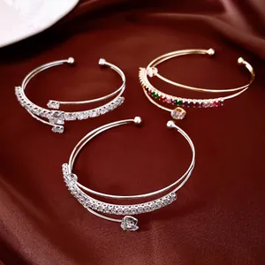 Gros plan de bracelets joncs multicouches avec zircons étincelants en argent et or.
