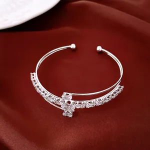 Vue détaillée d'un bracelet ouvert argenté multicouche orné de zircons carrés clairs.