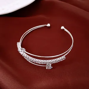 Vue détaillée d'un bracelet jonc argenté multicouche serti de zircons étincelants.
