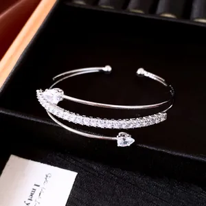 Détail rapproché d'un jonc argenté multicouche avec zircons carrés et en forme de poire