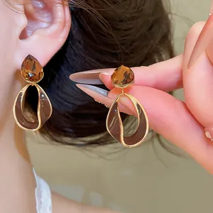 Detail of Maillard style earrings with 18k gold plating and brown teardrop crystals