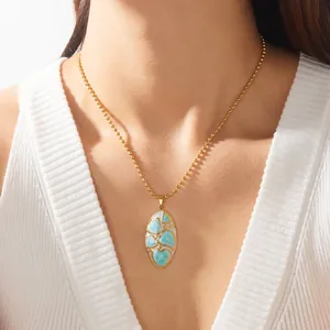 Vue détaillée d'un collier en acier doré avec un pendentif émaillé ovale bleu irrégulier.