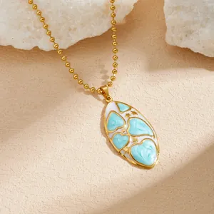 Vue détaillée du collier doré ovale avec émail en cœur bleu et petits motifs d'étoiles