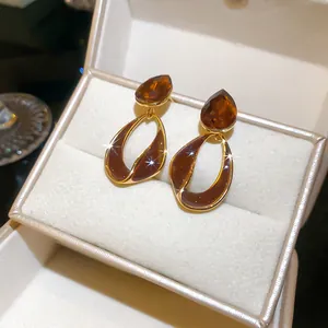 Macro view of vintage amber crystal earrings with 18k gold plating in a jewelry box