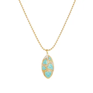 Gros plan d'un pendentif ovale plaqué or avec cœurs en émail bleu et étoiles.