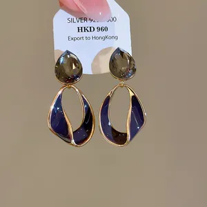 Detail of retro Maillard style earrings with 18k gold plating and dark enamel.