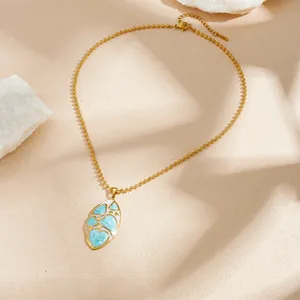 Détail du collier en acier inoxydable doré avec pendentif ovale cœur en émail bleu