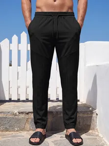Detalle que muestra el tejido texturizado único en pantalones negros de hombre casual.