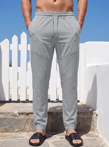 Vista frontal de joggers grises para hombre con cordón y paneles texturizados al aire libre
