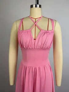 Close-up of elegant pink pleated high-waist maxi dress with crisscross straps
