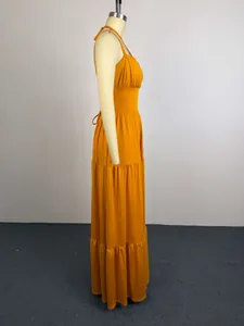 Side view of elegant ginger yellow pleated high waist maxi dress with tiered skirt