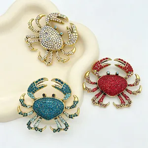 Detailed view of rhinestone-encrusted crab brooches in red, blue, and gold-tone finish.