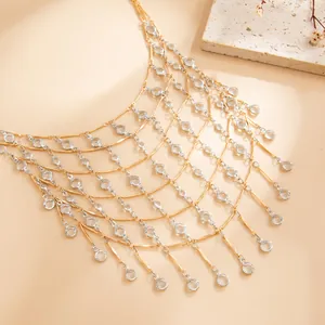Detailed view of sparkling gold and silver tassel necklace with clear crystal accents