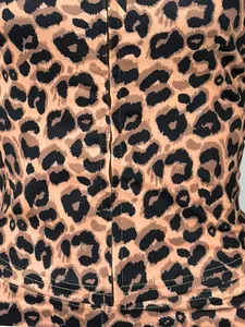 Détail rapproché montrant la texture du tissu et le zip de l'ensemble à capuche léopard