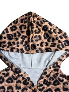 Détail en gros plan d'un sweat à capuche imprimé léopard avec fermeture éclair dorée.