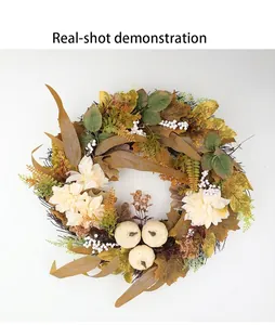 Vista detallada de la corona de cosecha de otoño con calabazas blancas y hojas de arce