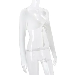 Close-up side view of white long-sleeve tie-front shrug top on a clear mannequin.