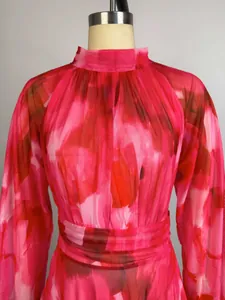Close-up detail of a pink watercolor printed dress featuring a gathered high neckline
