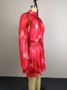 Side detail of long sleeve mesh mini dress featuring abstract red and pink print design