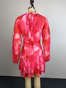 Back view of elegant summer floral mini dress with pleated waist and back bow detail.