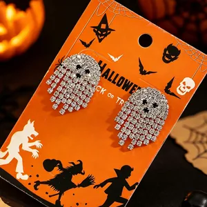 Detaillierte Nahaufnahme von silbernen Geisterohrringen auf oranger Halloween-Karte.