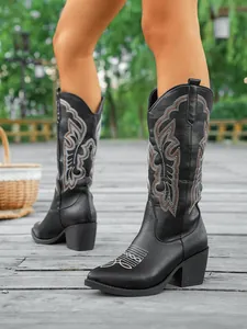 Vue détaillée de bottes de cow-boy noires brodées avec talon épais et bout pointu.