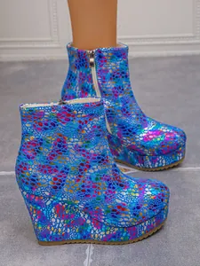 Detailed view of colorful platform wedge ankle boots with vibrant pattern and side zipper