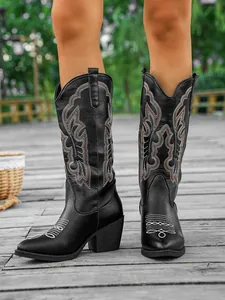 Détail de bottes de cowboy vintage noires brodées avec coupe en V et talons épais