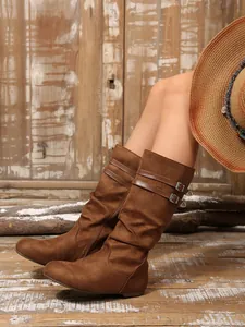 Detailed view of brown suede slouchy mid-calf boots with stylish double buckles.