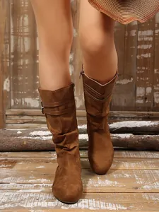 Detail view of brown slouchy knee-high boots with double buckle straps for women.