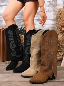 Detailed view of embroidered high-top cowboy boots in black, beige, and brown colors.