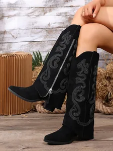 Detail view of black suede knight boots with intricate embroidery and pointed toe