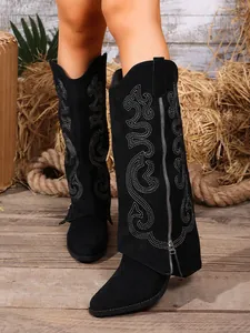 Detail view of black embroidered high-top boots with unique fold-over shaft design.