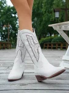 Detailansicht weißer Western-Cowboystiefel mit brauner Stickerei und stabilem Blockabsatz.