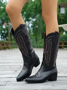 Hochwertige Detailansicht schwarzer bestickter Westernstiefel für Damen am Modell