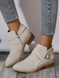 Beige faux suede pointed-toe ankle boots with square heel and buckle detail on model