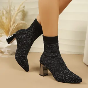 Elegant black glittery knit sock boots with pointed toe and metallic chunky heel.