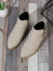 Detailed top-down view of beige pointed-toe ankle boots with side zipper and buckle