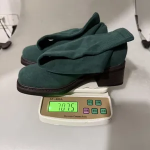 Detailed weight measurement of green chunky heel over-the-knee sock boots showing 707.5g