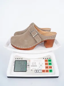 Muli beige con tacco alto e fibbia su una bilancia che pesa 0,27 kg