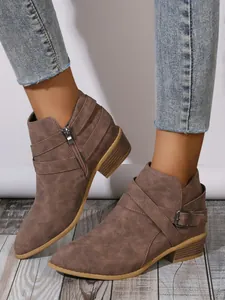 Detailed view of stylish brown pointed-toe ankle boots featuring side zipper and buckle