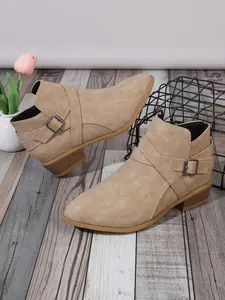 Detail view of khaki pointed toe block heel ankle boots with decorative side buckle